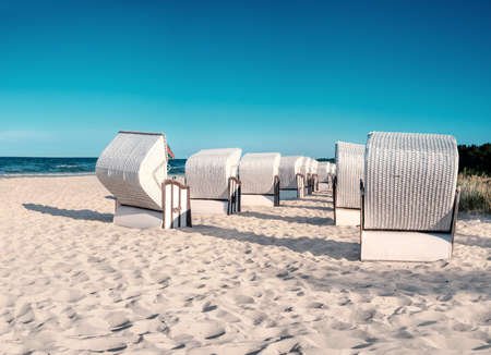 Sandy beach and traditional wooden beach chairs on island Rugen, Northern Germany, on the coast of Baltic Sea. Panorama, this image is toned.の写真素材