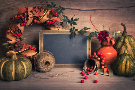 Blackboard with space for your greeting text with Autumn decorations on wood. This image is toned. 