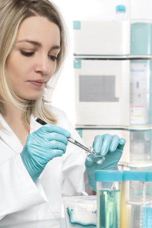 Young female tech or scientist picks up a piece of tissue from transparent jar. Shallow DOF, focus...