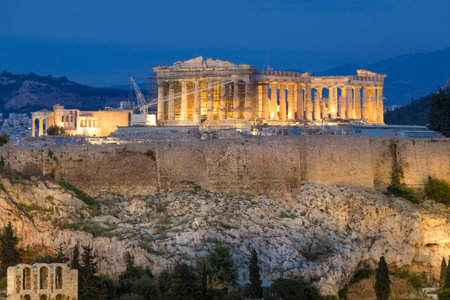 Parthenon and Herodium construction in Acropolis Hill in Athens, Greece, illuminated in the eveningの写真素材