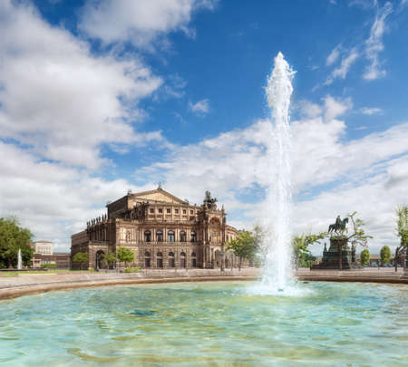 Opera house in Dresden on a sunny day, with sparkling fountain in the front. Panoramic image, text space. This image is toned.のeditorial素材