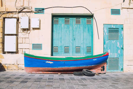 Colorful Malta, traditional fisherman boat on the pavement in front of the boat dockの写真素材