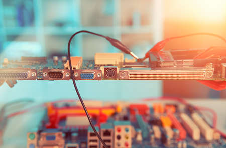 Closeup on electronic board in hardware repair shop, blurred and toned image, electronics backgroundの写真素材