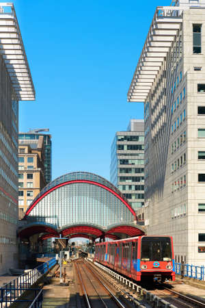 LONDON - MAY 2013: Canary Wharf, DLR station. DLR train leaving the station on a bright day.のeditorial素材