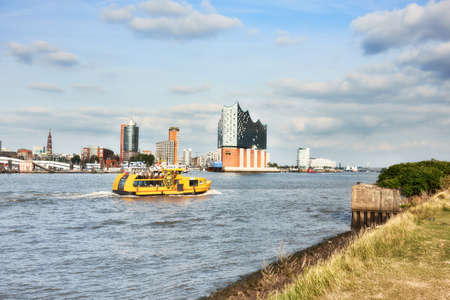 HAMBURG, GERMANY- AUGUST 12, 2015: Boat with tourists goes on Elbe river towards Elbphilharmonie, a concert hall in the Hafen City quarter of Hamburgのeditorial素材