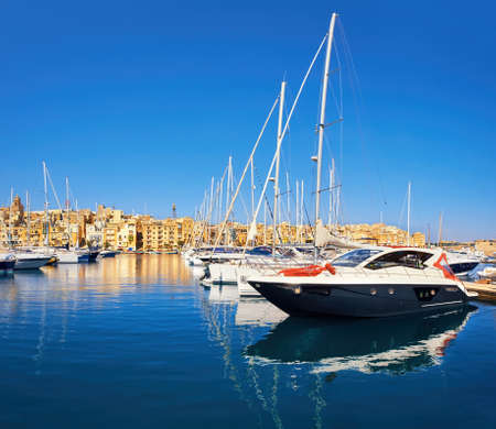 Sailing boats on Senglea marina in Grand Bay, Valetta, Malta, on golden morningの写真素材