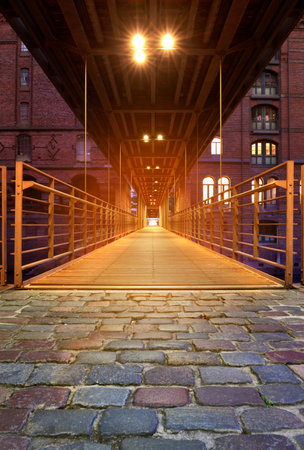 Speicherstadt, or warehouse district in Hamburg at night. Historical footbridge towards the old...