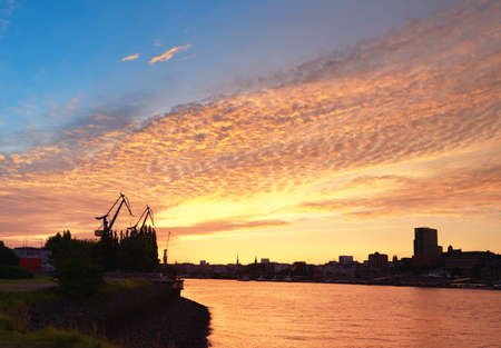 Hamburg Harbor in the sunset in Germany. Freight shipping cranes.の写真素材