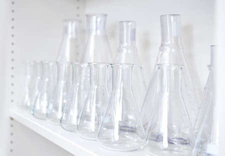 Conical flasks, shelf of clean laboratory glassware on white shelfの写真素材
