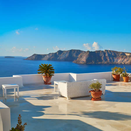 A view of beautiful sea and caldera with luxury roof terrace, typical white architecture of Santorini island, Greece. Panoramic image, square compositionの写真素材