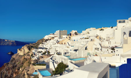 Beautiful Santorini in Greece - traditional windmill and apartments in Oia village on a sunny day. Panoramic image. This picture is toned.の写真素材