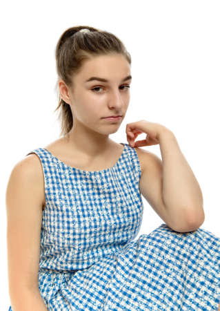 Cute teenage girl in casual striped dress looking at camera on white background, toned imageの写真素材