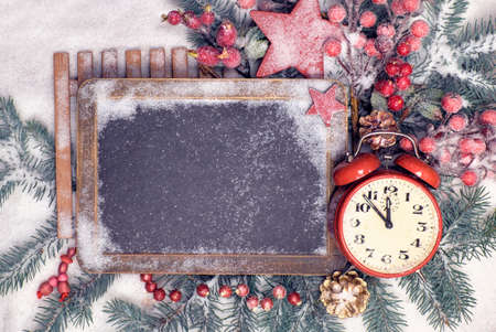 Empty blackboard with Christmas decorations and alarm clock on snow. Top view, text spaceの写真素材