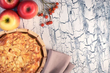Homemade apple pie with apples, berries and linen napkin on light rustic background.  Top view, toned image.の写真素材