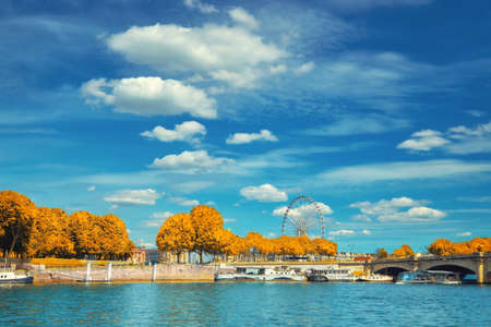 Beautiful Paris in Autumn. Riverbank of the river Seine with historical boats moored by the shore next to Concord square.This image is toned.の写真素材