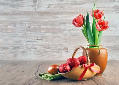 Red tulips and painted Easter eggs on wooden background, space for your textの写真素材