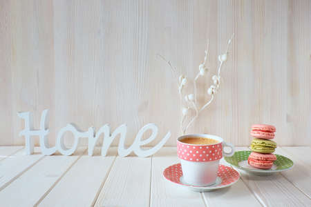 Spring coffee background. The word "Home" made of wood, white paper flowers, espresso and macaronsの写真素材