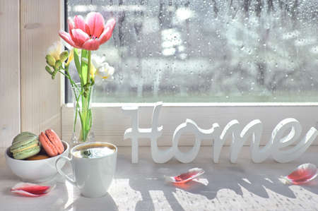 Cup of coffee, word "Home", pink tulips and white freesia on the window boardの写真素材