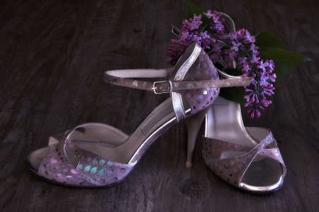 Argentine tango stilettos and lilac flower on dark wooden floorの写真素材