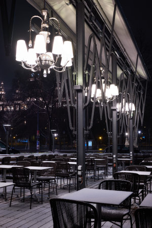 Outdoor terrase of a restaurant in central Vienna in winter at night under the snow