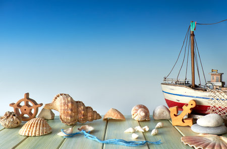 Summertime decorations: sea shells, wooden ship, anchor and stoned on blue gradient background, text...