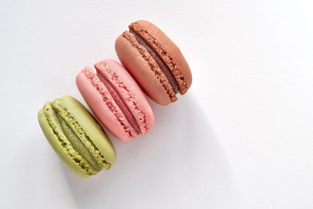 Sweet and colourful french macaroons or macarons on light gray background, text space