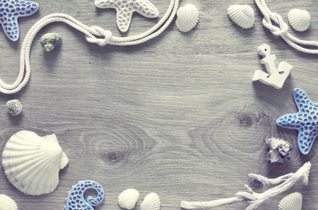 Frame made of sea shells, stones, rope and star fish on light textured background, text space