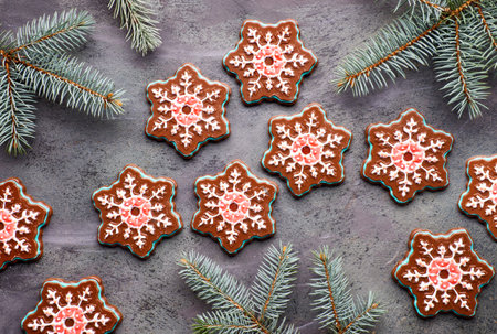 Snowflake chocolates with colorful icing on dark textured background with fir twigs. Christmas or...