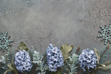 Winter floral border in green and blue with fir twigs, hyacinth flowers and leaves on green textured...