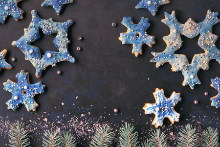 Christmas background, flat lay with snowflake and star cookies on dark background with fir twigs and...