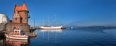 Rescue boat in front of historical brick building in Hafeninsel and historic sailship in Stralsund,...