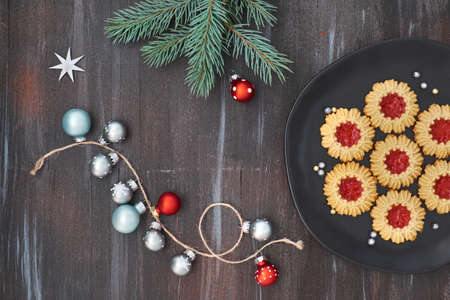 Flat lay with Xmas decorations in gray and red and jam cookies on dark grey wooden backgroundの写真素材