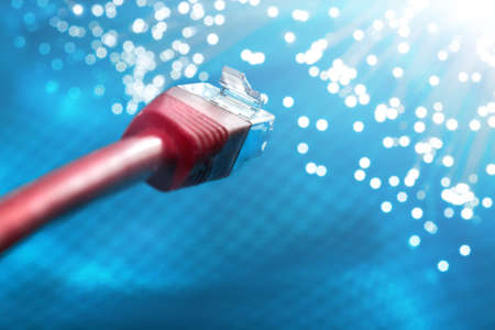 Futuristic technological background, closeup on the end of red optical fiber network cable on blue backgroundの写真素材