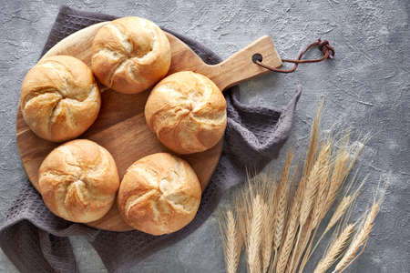 Crusty round bread rolls, known as Kaiser or Vienna rolls on linen towel, flat lay on rusticの写真素材