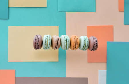 Row of tasty macarons, flat lay on geometric paperの写真素材