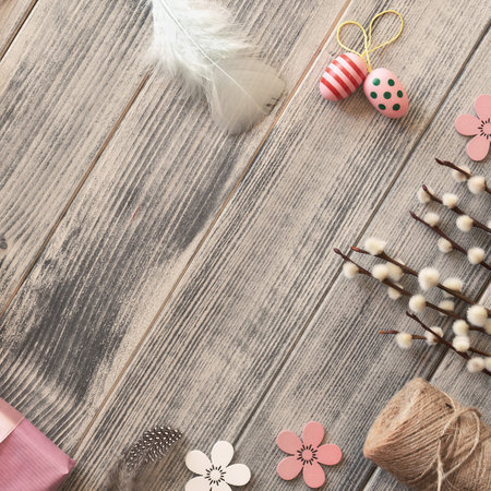Flat lay with copy-space  on dark wooden surface with spring decorations: Easter eggs, wrapped gift...