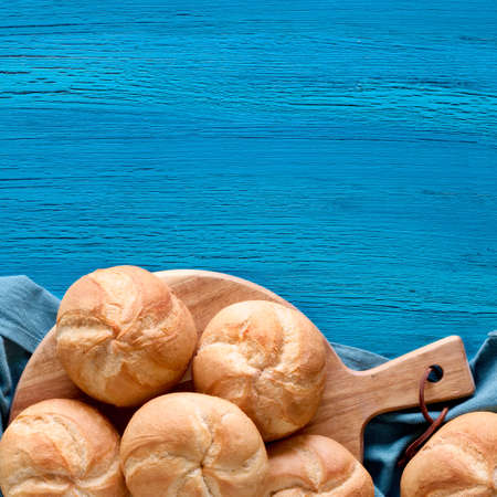 Crusty round bread rolls, known as Kaiser or Vienna rolls on linen towel. Flat lay on rustic background, square composition wiith copy-spaceの写真素材