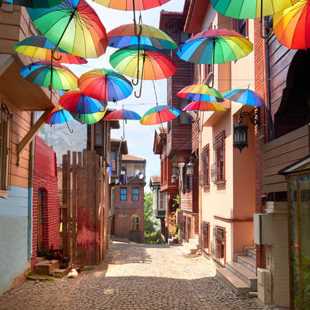Narrow pedestrian street in Istanbul, Turkey, with rainbow umbrellas on display above the walkawayの写真素材