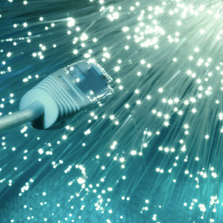 Futuristic technological background, closeup on the end of optical fiber network cable on blue...