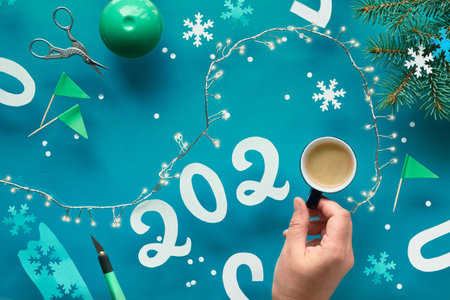 Winter holiday paper craft, making decorations for Christmas and New Year 2020, flat lay on green...