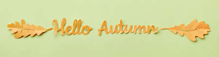 Paper text "Hello Autumn" with oak leaves. Panoramic image, lat lay on yellow paper.の写真素材