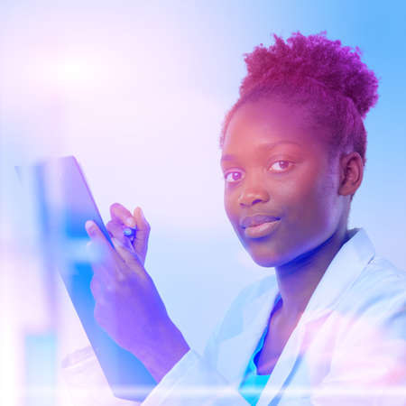 African scientist, medical or or graduate student. Confident young woman wearing lab coat holds a pen and a questionnaire. Square composition, futuristic neon glow, focus on the eyesの写真素材