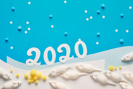 Happy New Year 2020! Creative paper flat lay in blue and white with marshmallow mice going for...