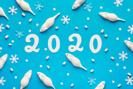Happy New Year 2020! Creative paper flat lay in blue and white with marshmallow mice, snowflakes and...