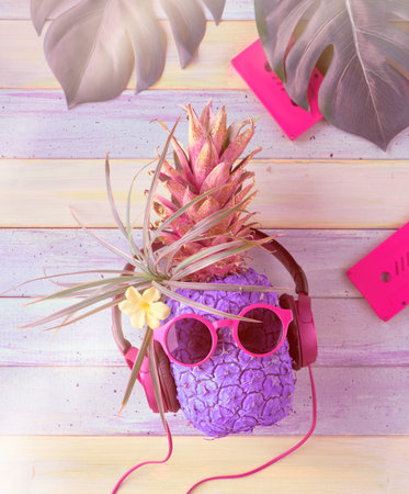 Hipster pineapple character in pink sunglasses and earphones listens to the music. Light rustic...