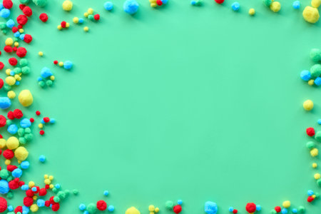 Light green paper background with lframe made of small fluffy balls, copy-space