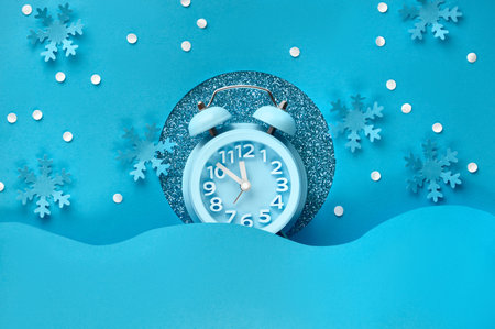 Happy New Year 2020! Aarm clock in paper hole, flat lay on blue color paper background