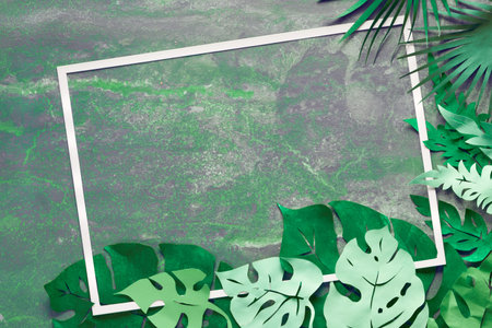 Paper craft background, frame with exotic tropical leaves with text space on dark textured...