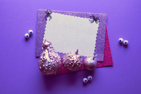 Creative Halloween background in purple, black, black and white colors with copy-space. Illuminated...