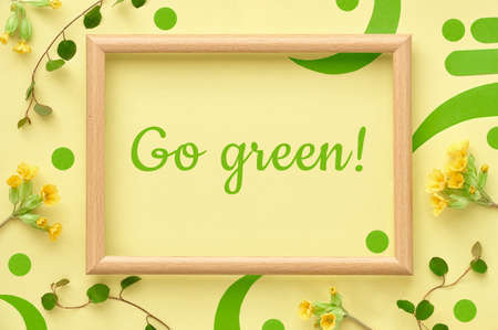 Wooden frame decorated with yellow primrose flowers and leavesの写真素材